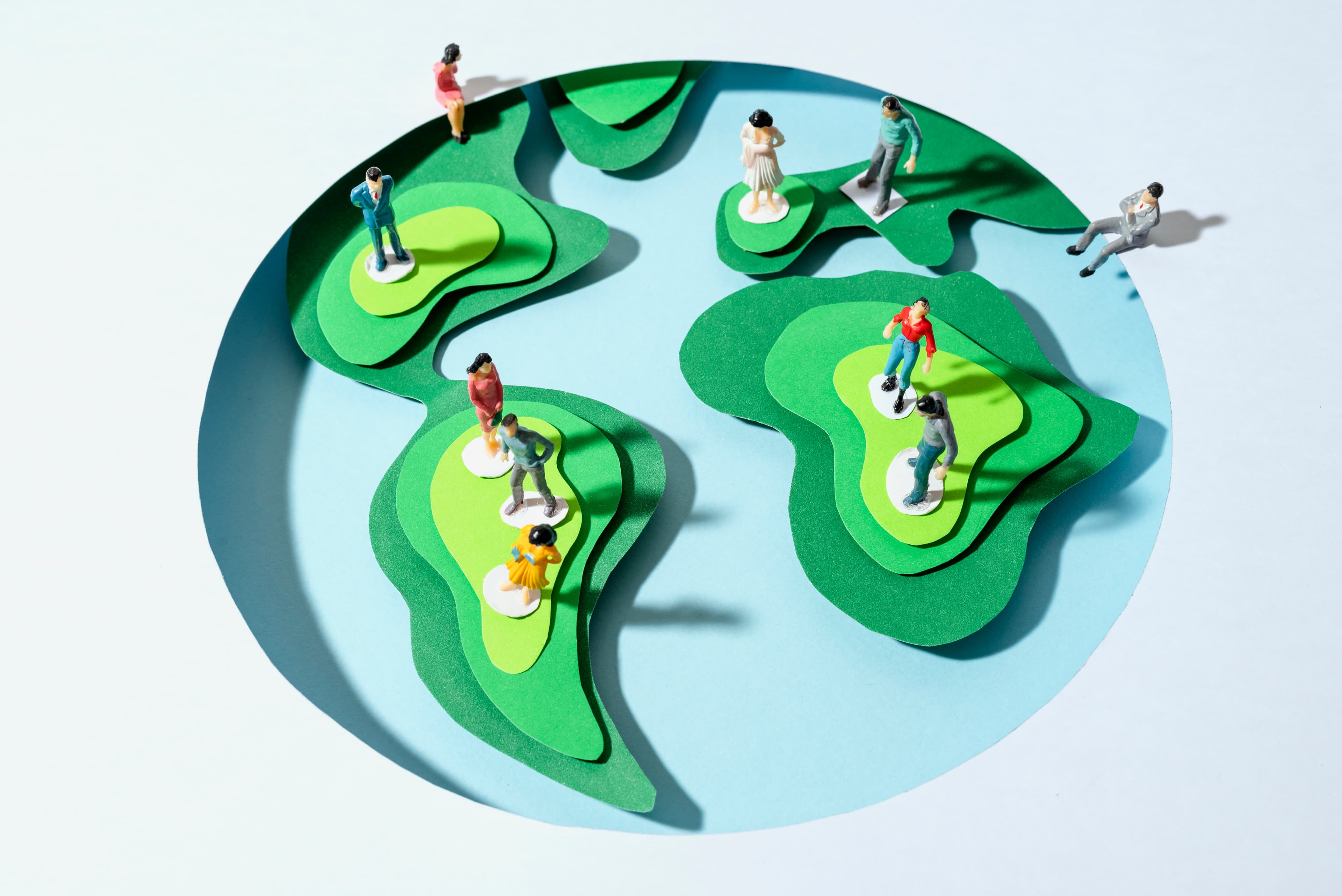 Miniature people standing on a globe to illustrate a global network.